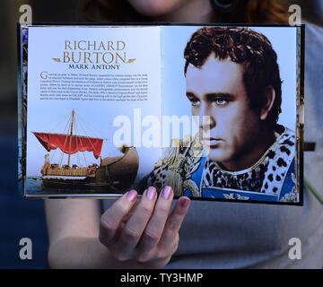 Un pubblicista visualizza una copia del "Cleopatra' DVD come Academy Award-winning attore Richard Burton riceve una stella postuma, durante una cerimonia di inaugurazione in onore di lui con la 2,491st stella sulla Hollywood Walk of Fame a Los Angeles il 1 marzo 2013. Burton starred con sua moglie, attrice Elizabeth Taylor, la cui star è accanto a Burton. UPI/Jim Ruymen Foto Stock