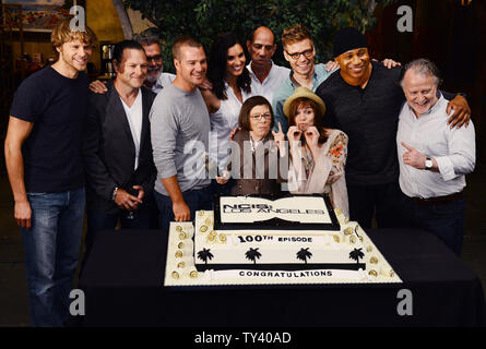 Membri del cast Eric Christian Olsen, Chris O'Donnell, Daniela Ruah, Miguel Ferrer, Barrett Foa, L.L. Cool J, Linda Hunt e Renee Felice Smith (L-R), sono uniti mediante lo spettacolo del produttori durante una di taglio della torta cerimonia per celebrare il CBS' 'NCIS: Los Angeles' riprese di loro 100th episodio, svoltasi sul set a Paramount Studios di Los Angeles il 23 agosto, 2013. UPI/Jim Ruymen Foto Stock