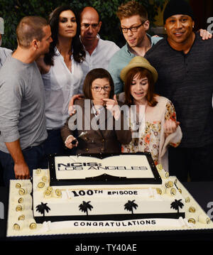 Membri del cast Chris O'Donnell, Daniela Ruah, Miguel Ferrer, Barrett Foa, L.L. Cool J, Linda Hunt e Renee Felice Smith (L-R), sono uniti mediante lo spettacolo del produttori durante una di taglio della torta cerimonia per celebrare il CBS' 'NCIS: Los Angeles' riprese di loro 100th episodio, svoltasi sul set a Paramount Studios di Los Angeles il 23 agosto, 2013. UPI/Jim Ruymen Foto Stock