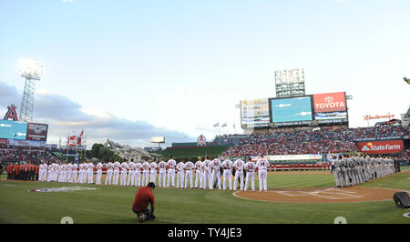 Il Los Angeles Angeli e Seattle Mariners stand per l'inno nazionale presso Angel Stadium di Anaheim, in California, il 31 marzo 2014. UPI/Lori Shepler. Foto Stock
