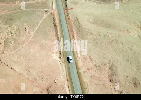 Unica vettura su una vecchia strada del deserto, antenna seguire l'immagine. Foto Stock