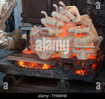 I lavoratori di fire adatta a rimuovere gli stampi riscaldati da un forno di colata durante la colata del premio di cooperativa di attori di schermo statuette presso la American Fine Arts Fonderia di Burbank, in California, il 17 gennaio 2017. I vincitori saranno annunciati durante una trasmissione in simulcast live su TNT e TBS a Los Angeles il 29 gennaio 2017. Foto di Jim Ruymen/UPI Foto Stock