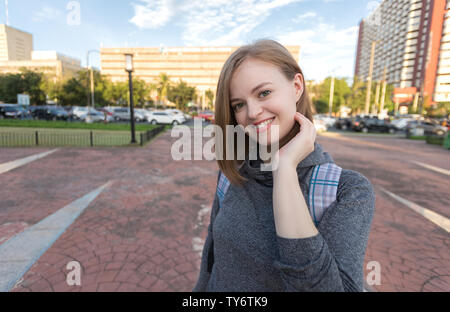 Ritratto di giovane sorridente donna caucasica viaggiatori con zaino Foto Stock