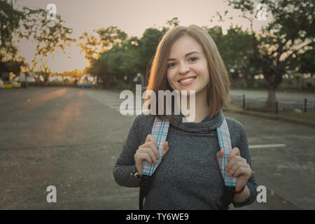 Ritratto di giovane sorridente donna caucasica viaggiatori con zaino Foto Stock