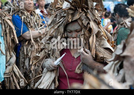 Devoti di prendere parte al 'Taong Putik' o fango festival di persone nella città di Bibiclat,Aliaga,Nueva Ecija,Filippine.Si tiene ogni anno il 24 giugno il secolo antica festa religiosa onora la santa cristiana, Giovanni Battista. Prima dell alba quelli coinvolti inserire vicino a campi di riso che ornano i loro corpi con fango & rendendo mantelli realizzati da strappato foglie di banano, ramoscelli, e vigne per emulare Giovanni Battista's aspetto quando aveva battezzato Cristo. Procedere attraverso le strade della processione è una forma di penitenza per raggiungere il loro locale parrocchiale una recita teatrale è eseguita raffiguranti la vita & Foto Stock