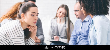 Triste lonely donna seduta a supporto della sessione di gruppo Foto Stock