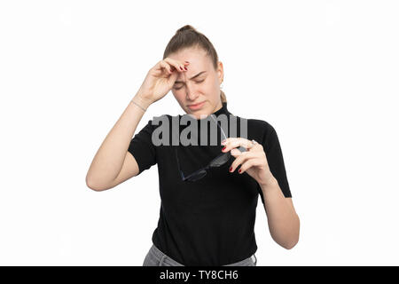 Giovane donna tiene i suoi bicchieri in mano e il mal di testa Foto Stock