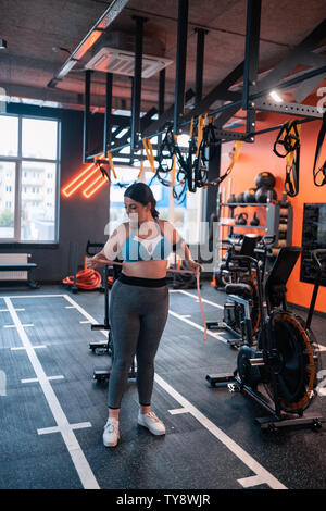 Paffuto donna misura girovita dopo allenamento nel centro fitness Foto Stock