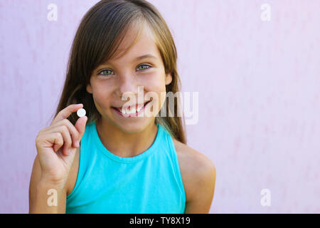 Felice ragazza con una pillola in mano. Foto Stock