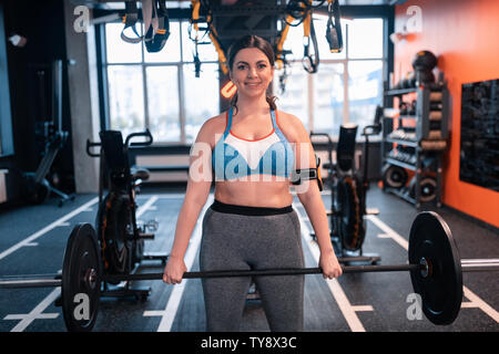 Paffuto dai capelli scuri azienda donna barbell feeling positivo Foto Stock