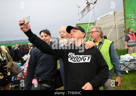 Organizzatore del Festival Michael Eavis (seconda a sinistra) prende selfies con fan come la gente arriva il primo giorno del festival di Glastonbury presso l'azienda agricola degna in Somerset. Foto Stock