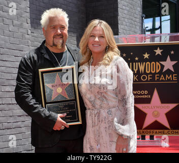 La televisione americana personalità, ristoratore e chef Guy Fieri detiene una placca di replica come egli è affiancato dalla moglie Lori Fieri durante una cerimonia di inaugurazione in onore di lui con la 2,664th della stella sulla Hollywood Walk of Fame a Los Angeles il 22 maggio 2019. Foto di Jim Ruymen/UPI. Foto Stock