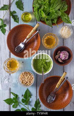 La cucina italiana. Pasta con pesto di basilico e pinoli. Gli ingredienti sono il vino, il formaggio parmigiano e aglio - al gusto. Ricetta classica Foto Stock