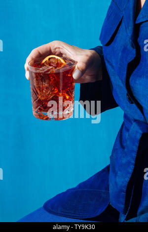 Donna e Negroni cocktail con gin, amaro e vermouth. Colorato e alla moda. Foto Stock