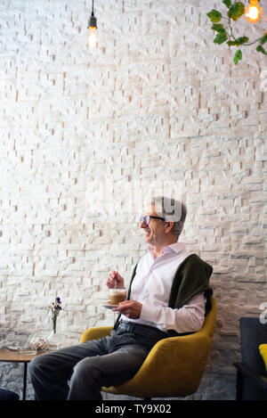 Senior man aventi una tazza di caffè nel bar Foto Stock