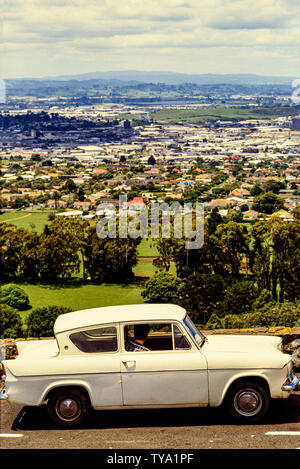 Nuova Zelanda, Isola del nord di Auckland. Un vecchio Ford Anglia auto con un autista guardando sopra la città. Foto: © Simon Grosset. Archivio: immagine digitalizzata dalla Foto Stock