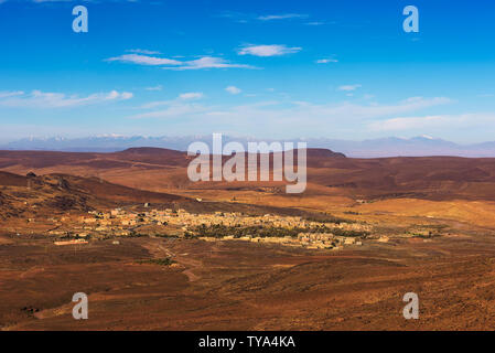 Vista su un villaggio in Marocco con innevate montagne Atlas in background Foto Stock