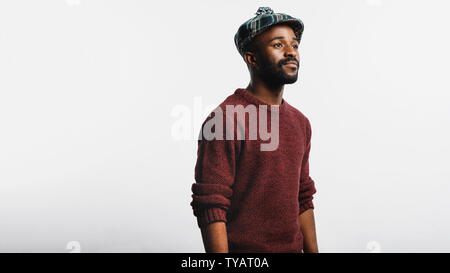 Uomo che indossa il cappuccio scozzesi isolate su sfondo bianco. Vista laterale di African American uomo in abbigliamento invernale. Foto Stock