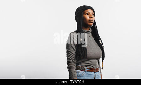 Donna africana isolato su sfondo bianco. Ritratto di donna africana in jeans e maglietta con lunghi dreadlocks. Foto Stock