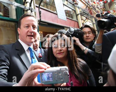 Partito conservatore leader David Cameron (L) prende le foto con i sostenitori mentre sul sentiero di campagna al mercato Leadenhall il 23 aprile 2010 a Londra, Inghilterra. UPI/Hugo Philpott Foto Stock