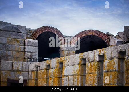 Grande struttura grigia in pietra con stampo giallo e archi Foto Stock