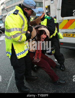 Un manifestante femmina è arrestato in corrispondenza di un anti-capitalista protestare contro le ingiustizie del sistema bancario mondiale a Londra il sabato 15 ottobre 2011. Circa due mila manifestanti pacifici hanno riempito St.Pauls piazza vicino al London Stock Exchange con una forte presenza di polizia. UPI/HugoPhilpott Foto Stock