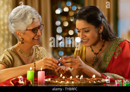 Nuora decorare la casa con la madre in legge in occasione del Diwali Foto Stock
