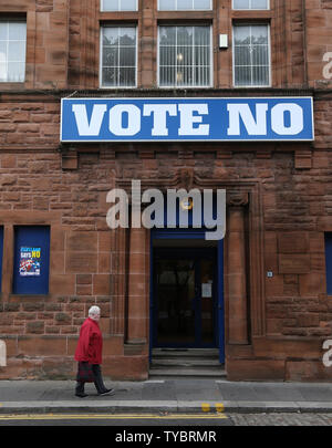 Una donna cammina davanti a un edificio con un grande 'votare No' poster contro l'indipendenza sul giorno residenti scozzese decidere il futuro direzione politica del loro paese terrà a Glasgow, Scozia il 18 settembre 2014. Novanta sette per cento della popolazione ha registrato per votare. Il verdetto sarà annunciato domani mattina. UPI/Hugo Philpott Foto Stock