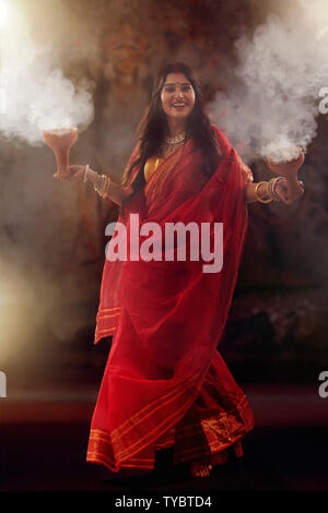 Bengali le donne sposate eseguendo dhunuchi ballo in occasione di durga puja Foto Stock