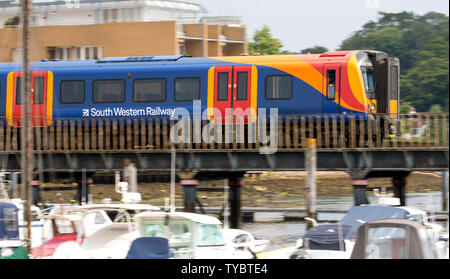 South Western Railway treno attraversando un ponte sul fiume a Lymington voce al traghetto Lymington Foto Stock