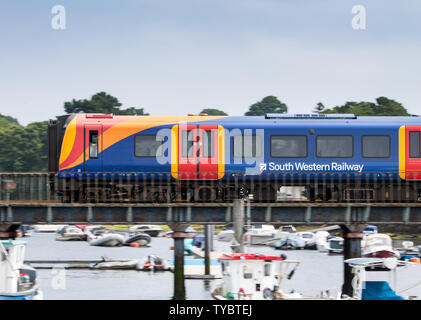 South Western Railway treno attraversando un ponte sul fiume a Lymington voce al traghetto Lymington Foto Stock