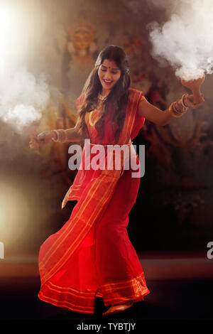 Bengali le donne sposate eseguendo dhunuchi ballo in occasione di durga puja Foto Stock