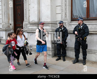 I turisti a piedi passato POLIZIOTTO ARMATO il giorno in cui il Regno Unito ha eletto il nuovo primo ministro, Theresa Maggio, il 9 giugno 2017 a Londra. Leader conservatore maggio è stata costretta a formare una coalizione con il democratico partito unionista ad avere una maggioranza in Parlamento. Foto di Hugo Philpott/UPI Foto Stock