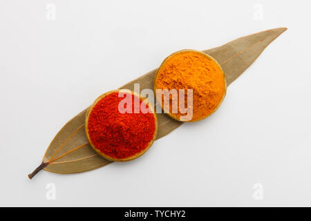 Turmeric powder and chilli powder in bowls on a malabar leaf Stock Photo