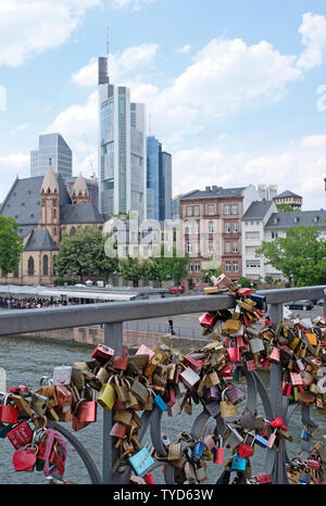 Frankfurt am Main, Germania - 15 Giugno 2019: Amore blocca adornano un ponte a Francoforte con lo skyline della città in background Foto Stock