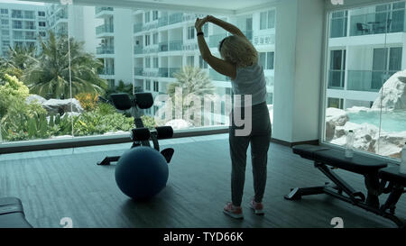 Pattaya, Tailandia - 15 Maggio 2019: donna anziana rende squattings in palestra. Donna anziana donna Senior fa un sport esercizi in palestra. Foto Stock