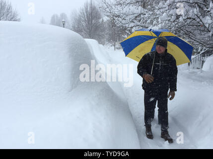 Maryland resident Jim Strnisha passeggiate auto passato sepolto sotto due metri di neve durante un Mid-Atlantic tempesta invernale Gennaio 23, 2016 in Frederick, Maryland. Foto di David Tulis/UPI Foto Stock