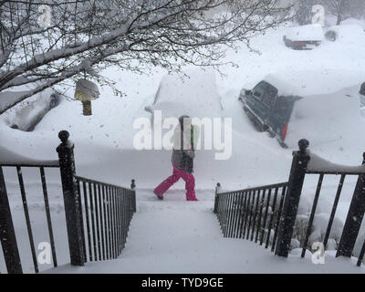 Un residente del Maryland cammina con il suo bambino passato auto sepolta sotto più di due metri di neve durante un Mid-Atlantic tempesta di neve Gennaio 23, 2016 in Frederick, Maryland. Foto di David Tulis/UPI Foto Stock