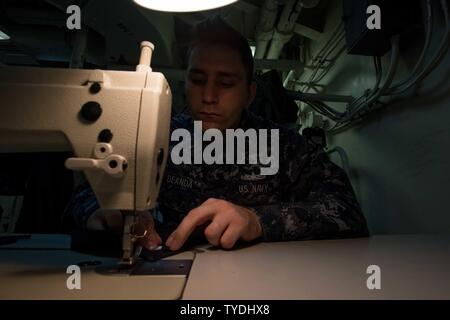 Washington (nov. 2, 2016) Il Marinaio Javier Deanda, da Sacramento, California, cuce il rango su una uniforme in USS John C. Stennis' (CVN 74) negozio di sartoria. John C. Stennis sta effettuando una manutenzione programmata la disponibilità su base navale Kitsap-Bremerton. Foto Stock