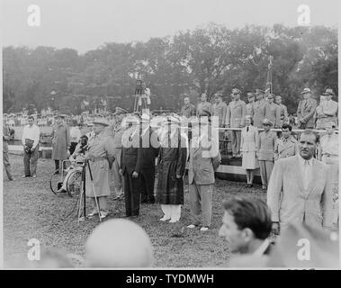 Fotografia del Presidente Truman a parlare davanti a un microfono durante la sua revisione del 442nd Nisei Regimental Combat Team, mentre altri dignitari a guardare. Foto Stock