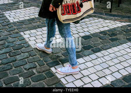 Moda Donna jeans blu e snickers sulla roccia cubi strada su una zebra crossing Foto Stock