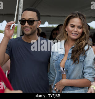 Il cantautore John Legend e sua moglie di Sports Illustrated cover model Christine Teigen presso la seconda annuale di celebrity chef torneo di pallavolo tra gli sport illustrato 2014 modelli di costume da bagno e top chef professionisti in Miami Beach, Florida, 20 febbraio, 2014. UPI/Gary mi Rothstein Foto Stock