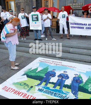 Gli ucraini indossando bianco in t-shirt supporto di lettura, non punire tenere un banner durante un rally repressiva contro le politiche sugli stupefacenti di fronte l'amministrazione presidenziale a Kiev.Il rally è stato parte della campagna globale 'Support, non punire" tenutosi a sostegno di sui diritti di tossicodipendenti persone ed era temporizzata su la Giornata Internazionale contro l abuso di droga e circolazione illegale e della Giornata Internazionale a Sostegno delle Vittime della tortura che di entrambi sono segnati il 26 giugno. Foto Stock