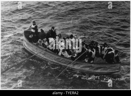 Fotografia di una scialuppa di salvataggio che trasportano TITANIC superstiti. La seguente didascalia parziale viene visualizzato sul retro del tappetino fratturato: ...M.P. Harris, Geo. Thinis (?), il sig. e la sig.ra J. Milton (?), M.P. Staffanson (?), H. Woolman (?), Nairatil (?) bambini, Mys. Compton in stern - trasferiti da n. 14. La scrittura su questo tappetino è sbiadito e difficile da leggere. Foto Stock