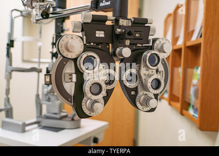 Immagine tecnica di un phoropter in un occhio medici office con sfondo sfocato. Foto Stock