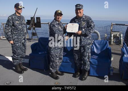 Mare (5 Nov 2016) - Cmdr. Ken Pickard, comandante, USS Carney (DDG 64), al centro, si è aggiudicata il servizio meritevole medaglia da Capt. Ricca Dromerhauser, commodore, Destroyer Squadron 60, durante un cambiamento di cerimonia di comando a bordo della USS Carney (DDG) 64 nov. 5, 2016. Carney, un Arleigh Burke-class guidato-missile distruttore, distribuita a Rota, Spagna, sta conducendo una pattuglia di routine negli Stati Uniti Sesta flotta area di operazioni a sostegno degli Stati Uniti per gli interessi di sicurezza nazionali in Europa. Foto Stock