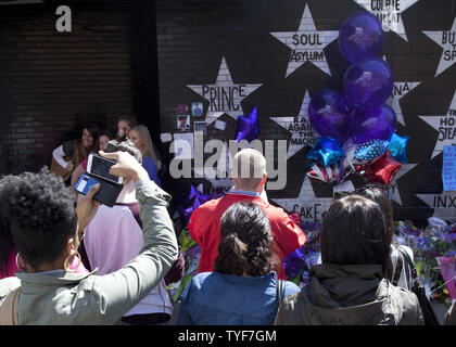 Ventilatori per rendere omaggio al principe (nato Prince Rogers Nelson) al di fuori del night club, First Avenue, dove il viola uno ha iniziato la sua carriera in aprile 22, 2016 a Minneapolis, Minnesota. Il principe è morto il 21 aprile all'età di 57. Foto di Marilyn Indahl/UPI Foto Stock