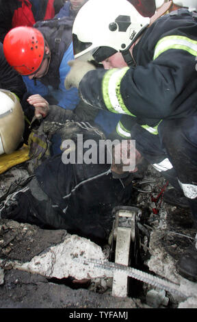 Soccorritori recuperare un uomo ferito dalle macerie di un crollato edificio di mercato a Mosca, 23 febbraio 2006. Il mercato Bauman nella parte orientale di Mosca è crollata forse a causa del peso della neve sul tetto, uccidendo almeno 45 persone e cattura di altri in macerie. (UPI foto/Anatoli Zhdanov) Foto Stock