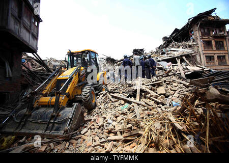 Gli operatori di soccorso di rimuovere i detriti come la ricerca per le vittime del terremoto in Bhaktapur, Nepal, 26 aprile 2015. Nuovi tremori inviato scioccato scurrying sopravvissuti all'aperto appena 24 ore dopo una devastante 7.9 grandezza terremoto fece tremare la regione, tenendo la vita di almeno 2.500 persone, nepalesi hanno detto i funzionari. Foto di Sanjog Manandhar/ UPI Foto Stock