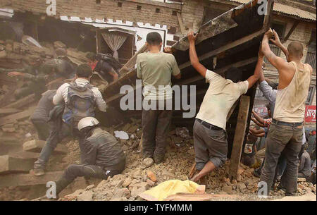 Gli operatori di soccorso di rimuovere i detriti come la ricerca per le vittime del terremoto in Kathmandu, Nepal, 26 aprile 2015. Nuovi tremori inviato scioccato scurrying sopravvissuti all'aperto appena 24 ore dopo una devastante 7.9 grandezza terremoto fece tremare la regione che finora ha preso la vita di molti, nepalesi hanno detto i funzionari. Foto di Sanjog Manandhar/UPI Foto Stock